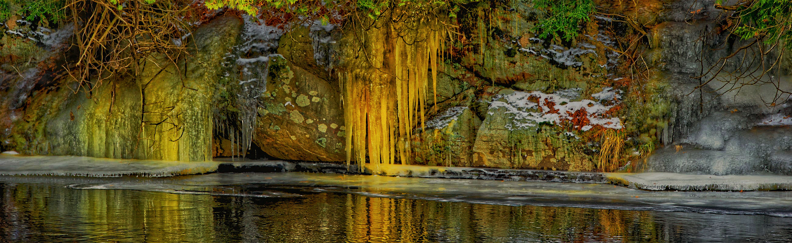 Frozen icicles on bank of river